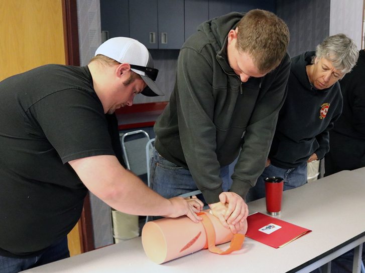 Civilians practicing wound pressure techniques in a Stop the Bleed classroom