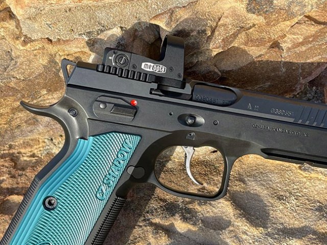Close-up of a pistol with a mounted red dot optic sight